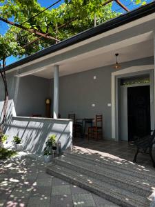a patio of a house with a table and chairs at Family Nest in Shtoji i Ri