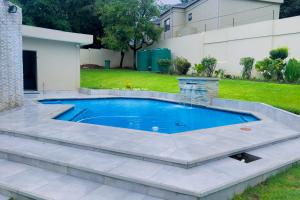 a swimming pool in a backyard with a landscaping at 157 on North-Sandton in Johannesburg