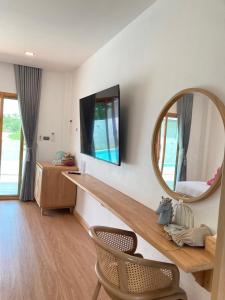 a room with a mirror and a table and a chair at Monanza Hotel in Ban Thung Prong