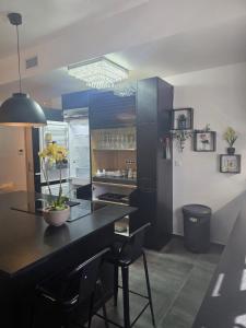 a kitchen with blue cabinets and a table with chairs at L'instant cosy climatisé 2 in Sisteron