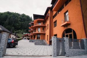 ein Gebäude, vor dem ein Auto geparkt ist in der Unterkunft Abigarrado in Rucăr