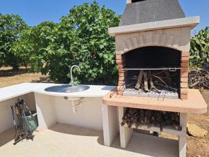 a outdoor pizza oven with a sink in it at pura natura Alghero in Alghero