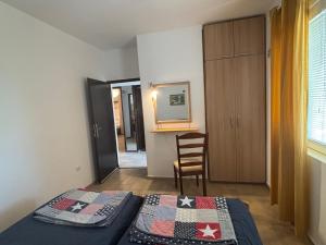 a small bedroom with two beds and a chair at Villa Marko in Sutomore