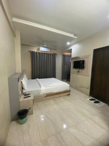 a bedroom with a bed and a flat screen tv at Hotel Bhiwandi Palace Nashik Highway Rd in Bhiwandi
