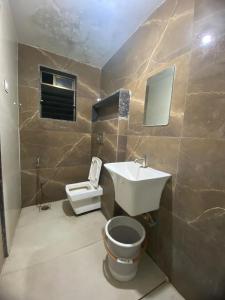 a bathroom with a sink and a toilet at Hotel Bhiwandi Palace Nashik Highway Rd in Bhiwandi
