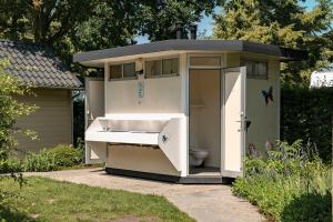 a outhouse with a toilet and a sink at Woodboxcabins - Campinggroenpark in Zele