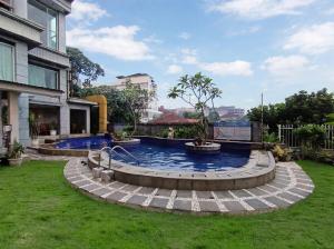 a swimming pool in a yard next to a house at Onih Hotel in Bogor