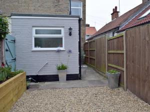 a small shed with a window and a fence at Albion Cottage in Pakefield