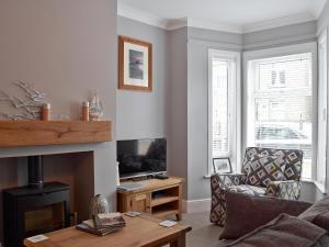 a living room with a couch and a fireplace at Albion Cottage in Pakefield
