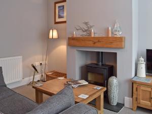 a living room with a table and a fireplace at Albion Cottage in Pakefield +6 photos