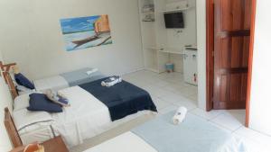 a bedroom with a bed and a television in a room at Pousada Sorriso da Mata.. in Alter do Chao