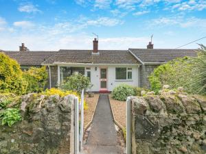 a house with a stone fence in front of it at Seashell Haven in Beadnell
