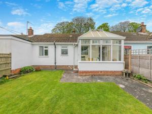 a house with a conservatory in a yard at Seashell Haven in Beadnell