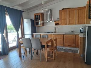a kitchen with a wooden table and chairs and a kitchen with a sink at pura natura Alghero in Alghero