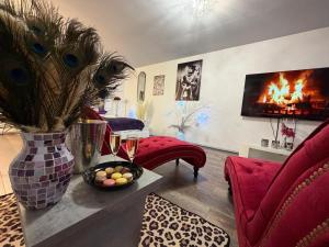 a living room with a red couch and a fireplace at So Chic Romance au pied du Château in Sedan