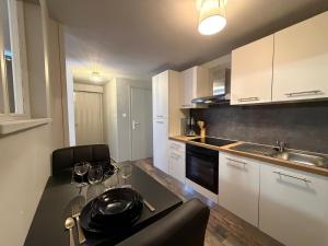a kitchen with a table with wine glasses on it at So Chic Romance au pied du Château in Sedan