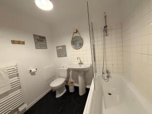 a bathroom with a toilet and a sink and a tub at So Chic Romance au pied du Château in Sedan +7 photos