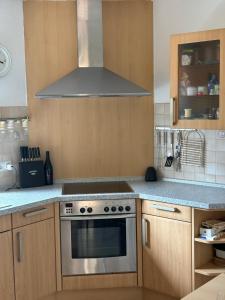 a kitchen with a stove and a hood at Harmonie im Grünen - Charmantes Erdgeschoss Privatzimmer mit Gartenzugang in Wathlingen +4 photos