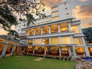 a large white building with tables and chairs at Onih Hotel in Bogor