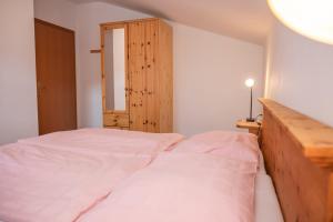 a bedroom with two beds and a wooden cabinet at Popp`n Angerl in Tauplitz