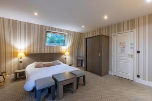 a hotel room with a bed and a table and a door at Résidence du Bas Mont in Moulay