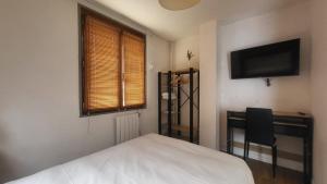 a bedroom with a bed and a desk and a television at Tsara Home in Le Trait