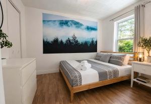a bedroom with a bed and a painting on the wall at Charlevoix spa bbq fire & nature in Saint-Tite-des-Caps