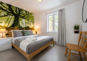 a bedroom with a bed with a tree mural on the wall at Charlevoix spa bbq fire & nature in Saint-Tite-des-Caps