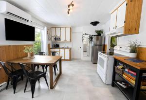 a kitchen and dining room with a table and chairs at Charlevoix spa bbq fire & nature in Saint-Tite-des-Caps