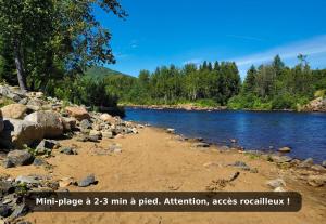 a river with rocks on the shore at Charlevoix spa bbq fire & nature in Saint-Tite-des-Caps +28 photos