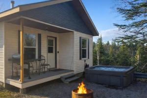 a tiny house with a hot tub and a grill at Charlevoix spa bbq fire & nature in Saint-Tite-des-Caps