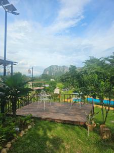 a wooden deck with chairs and a pool at SKYLINE vangvieng Resort in Vang Vieng