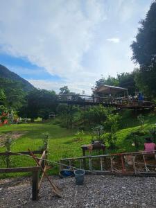a view of a playground with a bridge in the background at SKYLINE vangvieng Resort in Vang Vieng