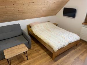 a small bedroom with a bed and a chair at Kubanka dom pokoje apartamenty in Płocice