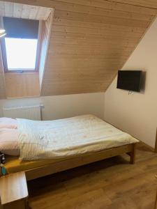 a bedroom with a bed and a tv on the wall at Kubanka dom pokoje apartamenty in Płocice