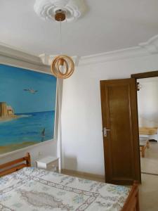 a bedroom with a bed and a painting on the wall at Appartement S2 Hammamet Centre in Hammamet +10 photos