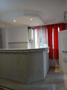 a kitchen with red curtains and a counter top at Appartement S2 Hammamet Centre in Hammamet