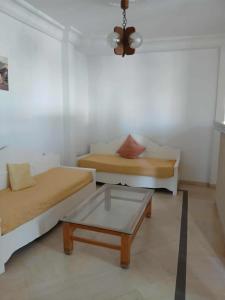 a living room with two beds and a coffee table at Appartement S2 Hammamet Centre in Hammamet