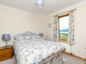 a bedroom with a bed and a window at Ach-Na-Clachan in Gairloch