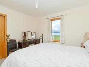 a white bedroom with a bed and a window at Ach-Na-Clachan in Gairloch