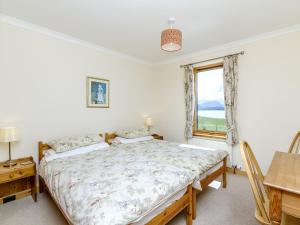 a bedroom with a bed and a table and a window at Ach-Na-Clachan in Gairloch +10 photos