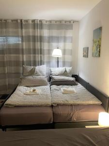 a bedroom with two beds with a lamp on it at Appartement am Brunnenplatzl mit Bademantelzugang in Bad Griesbach