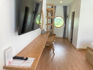 a room with a wooden table with a laptop on it at Monanza Hotel in Ban Thung Prong