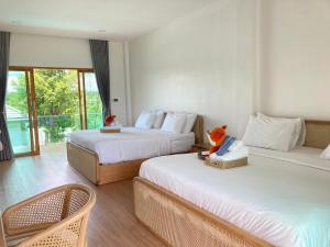 a hotel room with two beds and a balcony at Monanza Hotel in Ban Thung Prong