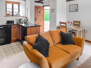 a living room with a couch and a kitchen at Brook Cottage - Ukc9515 in Beaworthy