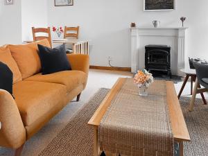 a living room with a couch and a fireplace at Brook Cottage - Ukc9515 in Beaworthy +9 photos