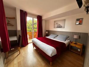 a bedroom with a bed with red curtains and a window at Hotel Restaurant La Source in La Foux