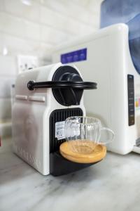 a coffee maker with a glass on a counter at Hideout Farmhouse - By Seven Elements in Ras al Khaimah
