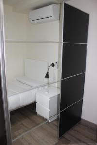 a small room with a bed and a desk and a mirror at Europa House Village in San Vicente del Raspeig