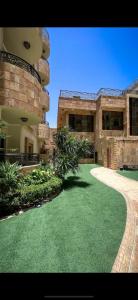a large building with a green lawn in front of it at Lanai Hotel فندق لاناي in Jeddah